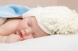 © golovianko - Cute sleeping baby in knitted hat with pompom