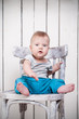 © golovianko - Baby boy sitting on chair in vintage interior