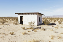 A Small Abandoned Building In The Mojave Desert Landscape.