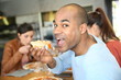 © goodluz - Young man having eating pizza slice