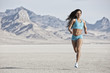 © Mint Images - A young woman running through the landscape on the salt flats surface near Salt Lake city.