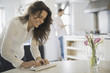 © Mint Images - Couple relaxing at home, woman using keyboard, man using smartphone