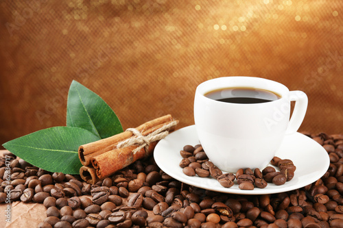 Naklejka na kafelki Coffee beans and cup of coffee on table on brown background