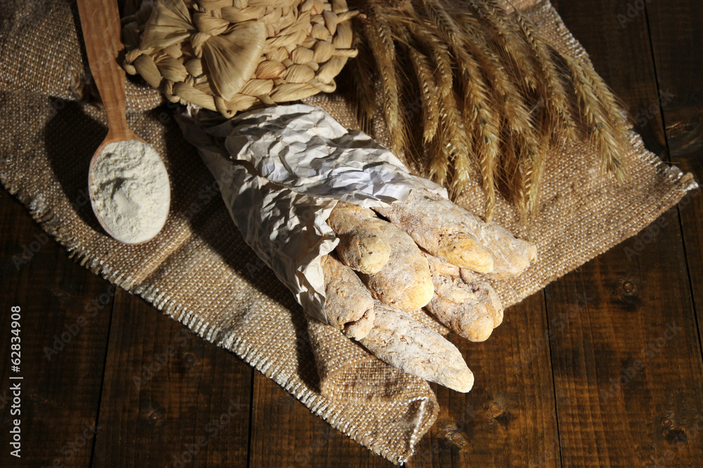 Bread sticks on sackcloth on wooden background