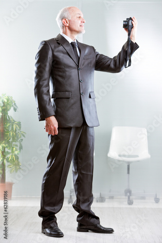 Fotografie, Obraz Strong standing businessman making a selfie