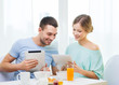 © Syda Productions - smiling couple with tablet pc reading news