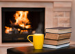 Cup of coffee with books on the background of the fireplace