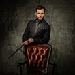 © Nejron Photo - Handsome well-dressed man with stick near chair