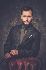 Wall Mural - Handsome well-dressed man with stick near chair