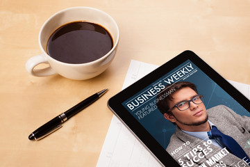 Wall Mural - tablet pc showing magazine on screen with a cup of coffee on a d