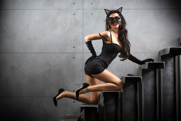 Poster - sexy woman in catwoman suit lying on stairs