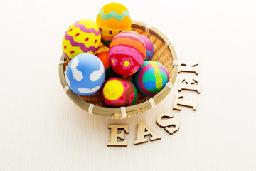 Easter egg in basket with wooden text