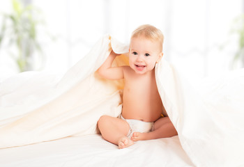 Wall Mural - happy baby under a blanket laughing