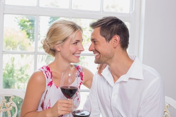 Wall Mural - Happy loving couple with wine glasses looking at each other