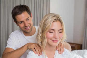 Wall Mural - Smiling man massaging woman's shoulders