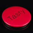 Magnetic red button with 'tasty' written on it