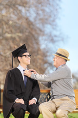 Wall Mural - College student and his proud father sitting in park