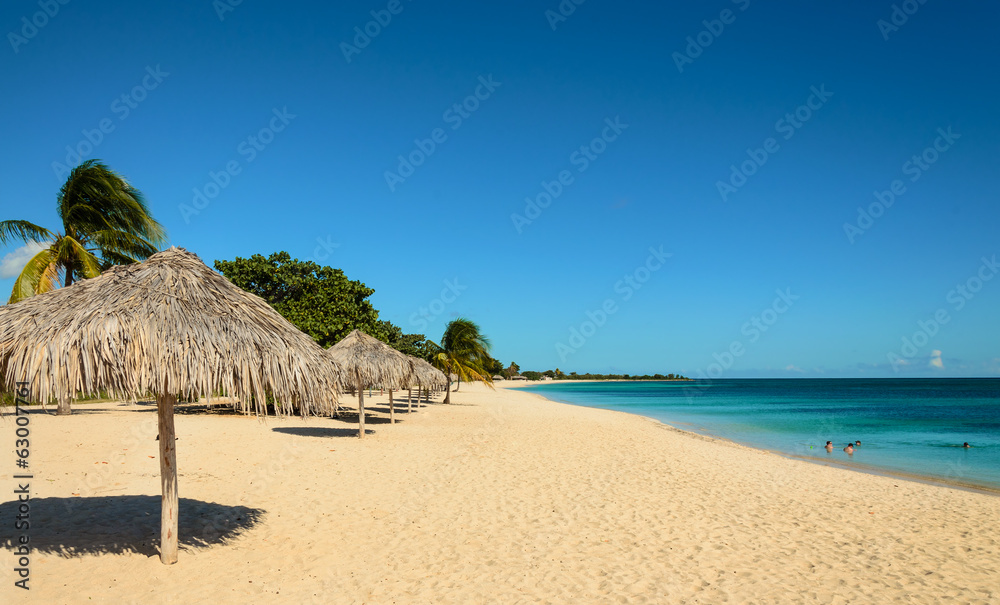 Caribbean beach with sun, palm tree umbrella, playa Ancon, Cuba - obrazy, fototapety, plakaty 