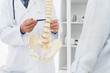© WavebreakMediaMicro - Mid section of doctor explaining the spine to patient