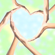 © wolfelarry - Human hands in heart shape over bright background