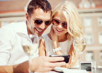 Wall Mural - couple looking at smartphone in cafe