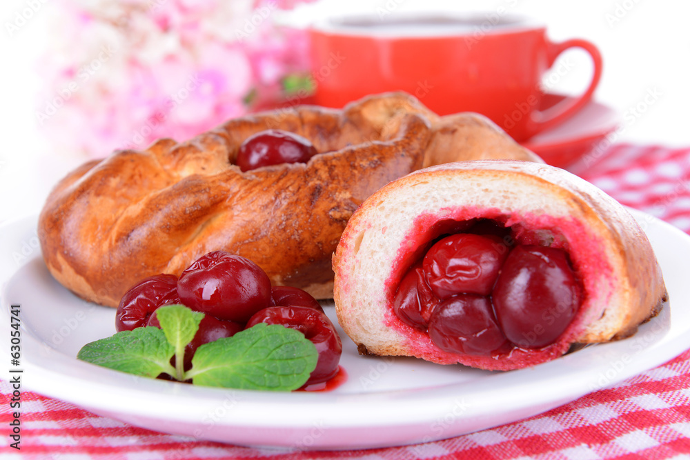 Fresh baked pasties with cherry on plate on table close-up