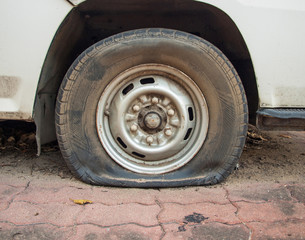 Deflated damaged tyre on car wheel