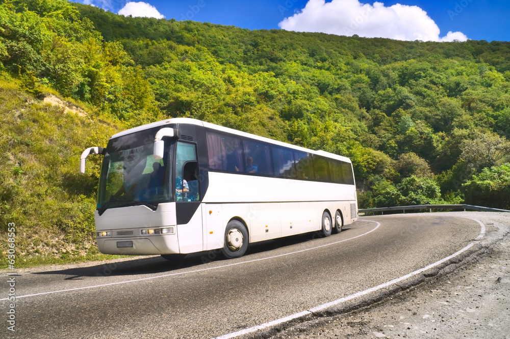 Tourist bus traveling on road among mountains - obrazy, fototapety, plakaty 