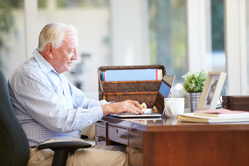 Canvas Print - Senior Man Using Laptop On Desk At Home