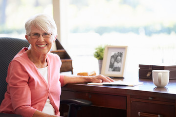 Wall Mural - Senior Woman Writing Memoirs In Book At Desk