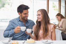 Smiling Couple Having Coffee At Coffee Shop
