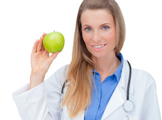 Wall Mural - Smiling  young female doctor giving an green apple.