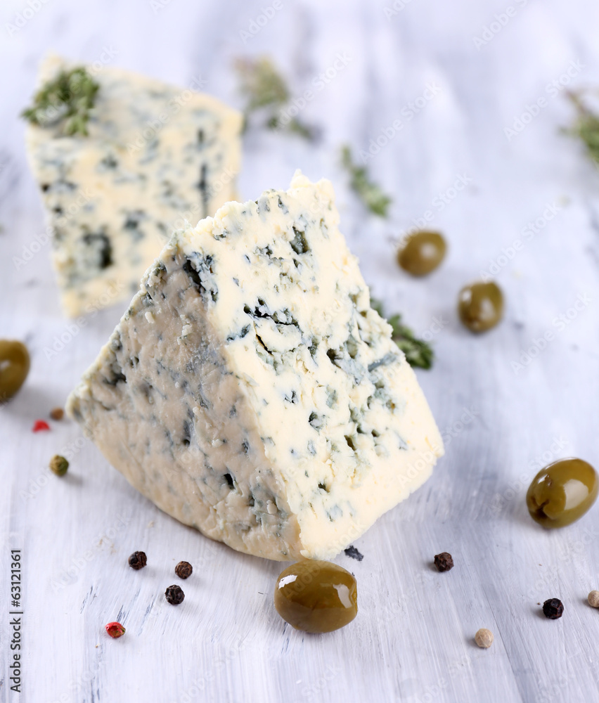 Tasty blue cheese with olives on wooden table
