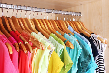 Colorful clothes hanging in wardrobe