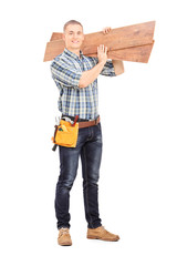 Male carpenter carrying planks over his shoulder