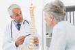 © WavebreakMediaMicro - Male doctor explaining the spine to senior patient