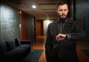 Handsome well-dressed man  looking at wrist watch 