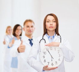 Poster - calm female doctor with wall clock