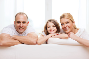 Canvas Print - smiling parents and little girl at home