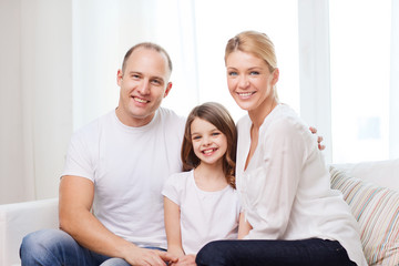 Canvas Print - smiling parents and little girl at home