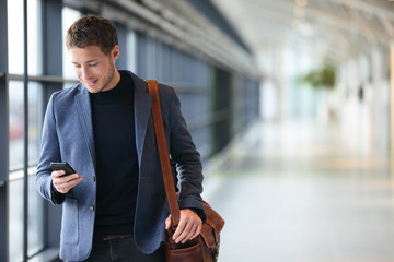 Man on smart phone - young business man in airport