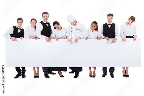 Fotografie, Obraz Group of catering staff holding a blank banner