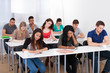 © Andrey Popov - College Students Writing At Desk