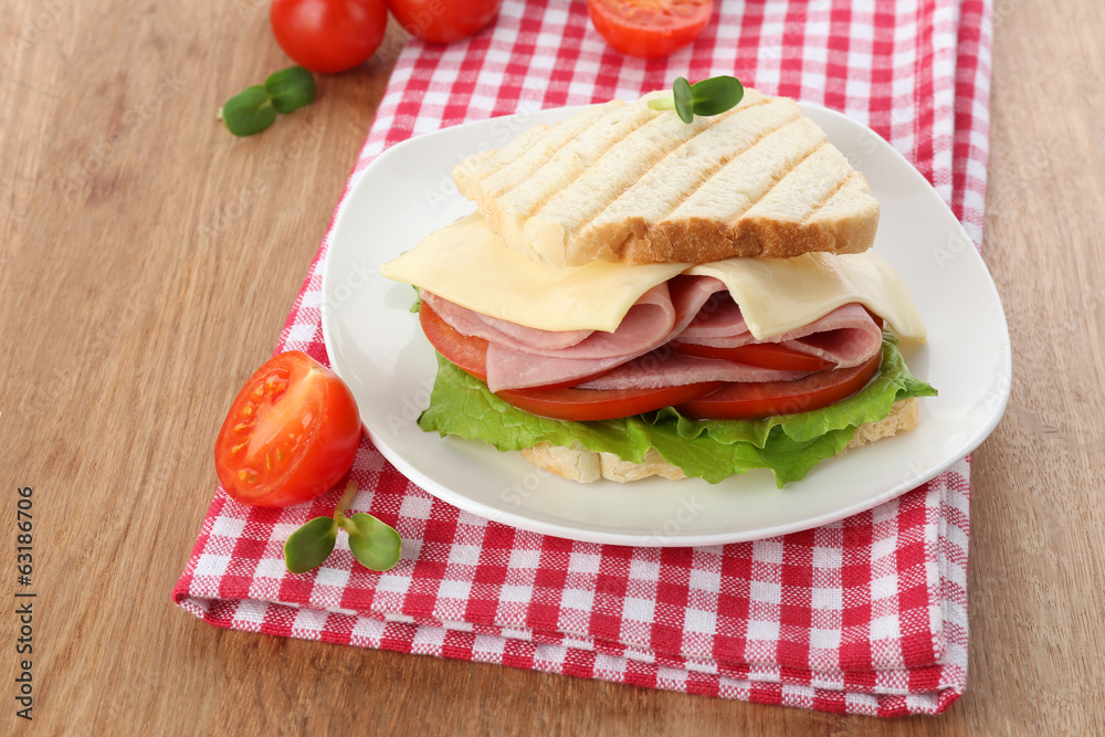 Tasty sandwich with ham on wooden table