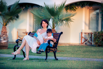 Happy mother and son sitting outdoors