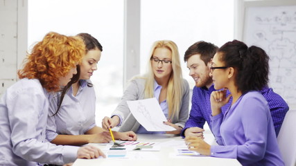 Canvas Print - smiling creative team looking at sketch