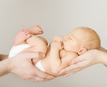 Baby Newborn Sleeping On Parents Hands, Kid And Family Concept