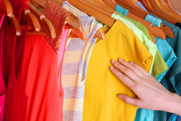 Colorful clothes hanging in wardrobe