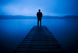 Man Standing on a Jetty by Tranquil Lake