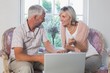 © lightwavemedia - Couple discussing while using laptop at home